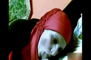 A menina de vermelho com o hijab chupando o pau fazer porno de uma foto em alta resolução